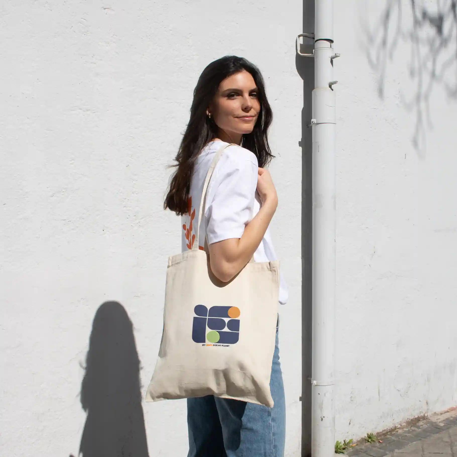 Cotton tote bag NATA 240 Chica paseando en la calle llevando una bolsa de algodón personalizada con logo de colores