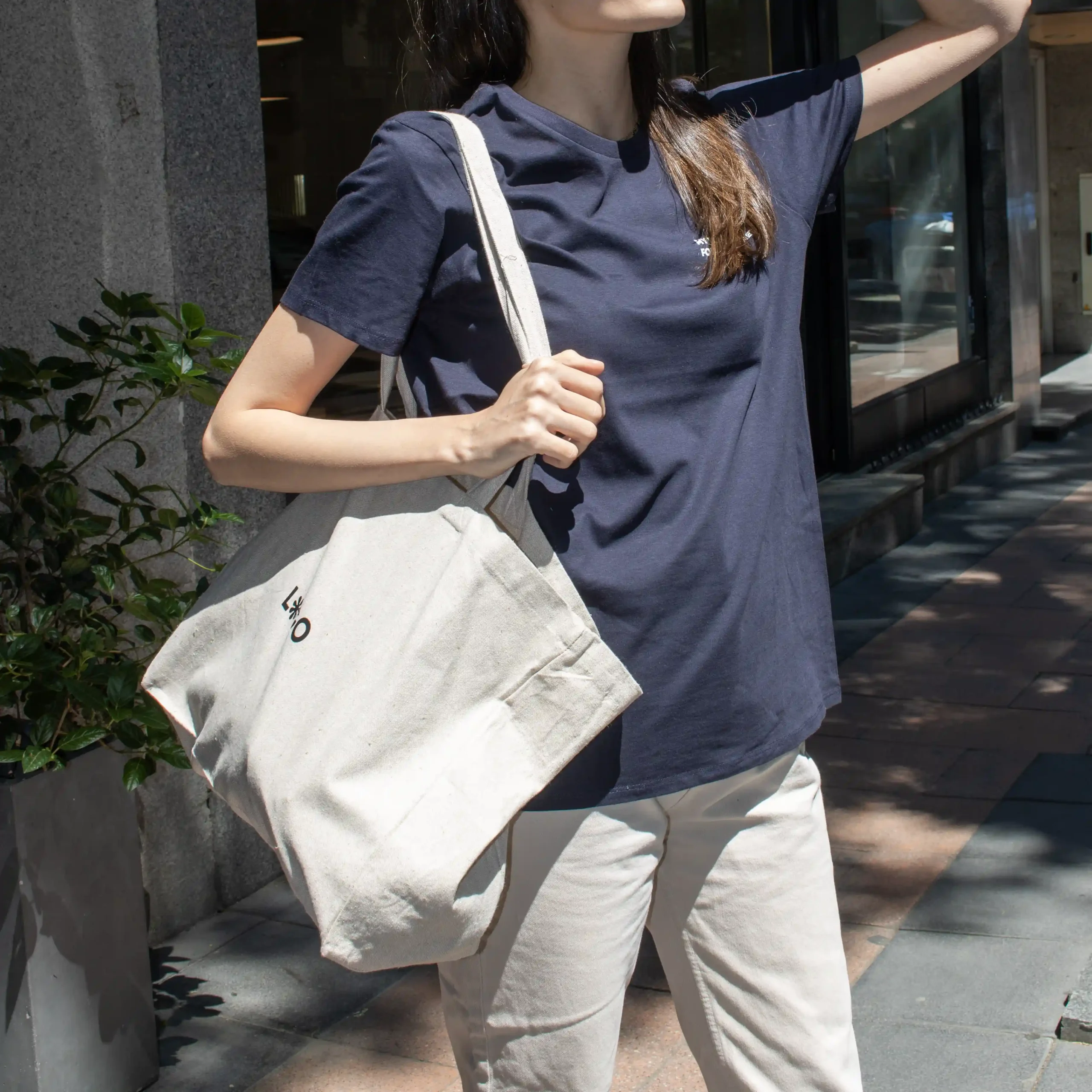 Bolsa de algodón reciclado PALMA Lifestyle Chica con camiseta azul caminando por la calle con bolsa de algodón reciclado