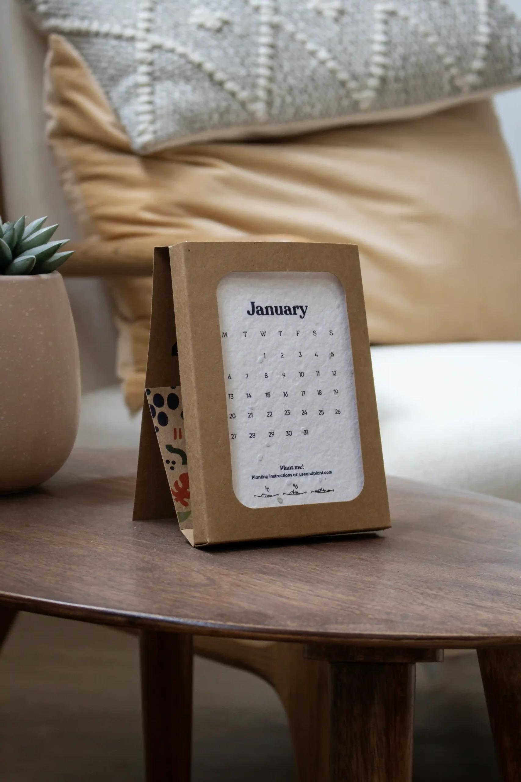 Calendrier des semences BOXE Calendario de semillas en estuche kraft personalizado colocado sobre una mesa madera