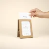 Mano sacando una hoja de un calendario de semillas en estuche kraft personalizado