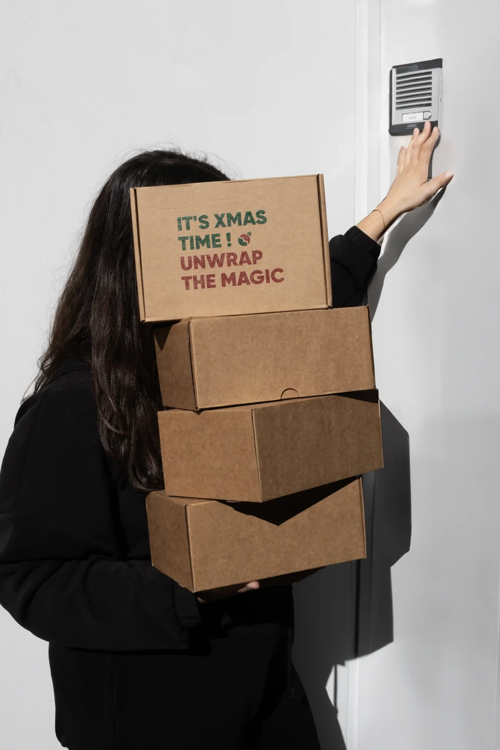 Chica cargando con cajas de regalo de Navidad personalizadas  