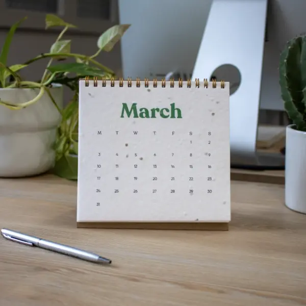 Calendario plantable de mesa abierto en el mes de marzo colocado en una mesa de trabajo