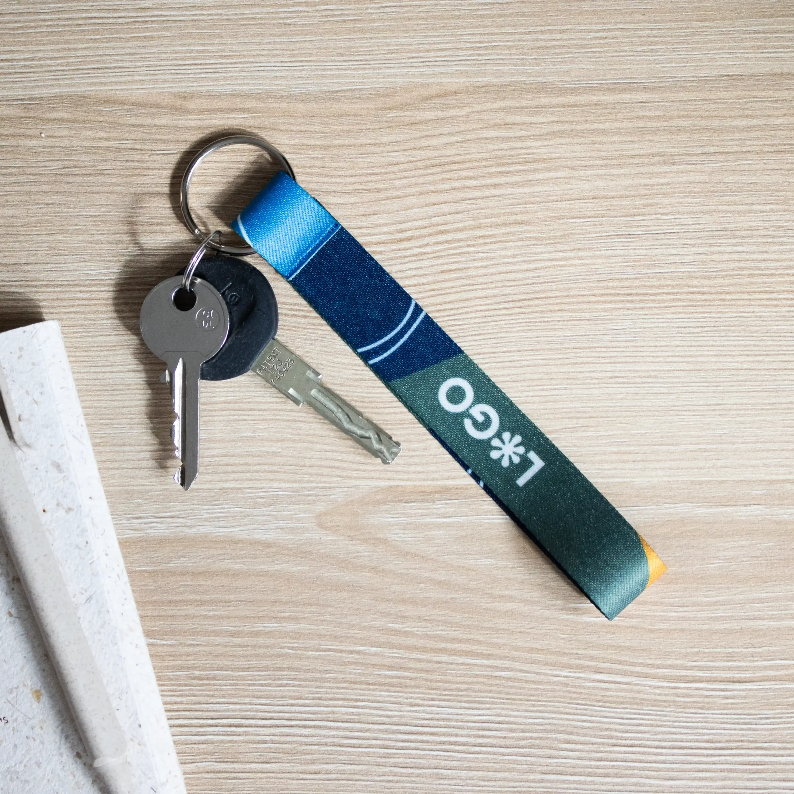 Llavero ecológico personalizado CLAUS Lifestyle llavero ecológico personalizado con logo con llaves sobre mesa de madera