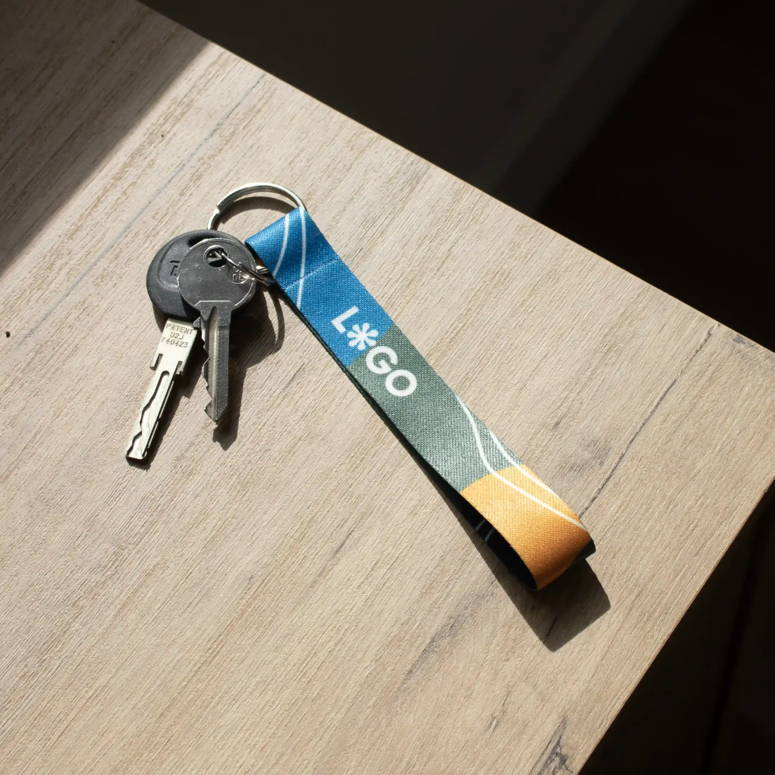 Llavero ecológico personalizado CLAUS llaves con llavero ecológico personalizado con logo sobre una mesa de madera