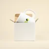 Taza blanca personalizada con la palabra logo en verde dentro de una caja blanca