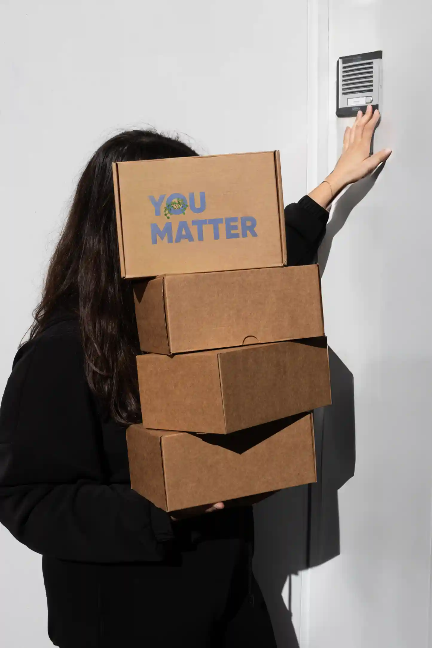 Welcome pack 'You matter' Chica cargando cajas de cartón personalizadas para welcome packs de empresa