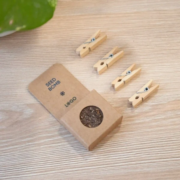 Bomba de semillas dentro de un packaging de cartón kraft personalizado sobre una mesa de madera