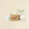 Taza take away beige, flyer de papel ecológico, camiseta blanca, tote bag de tela y una caja de cartón personalizados