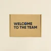 Caja de cartón cerrada personalizada con el texto 'welcome to the team'