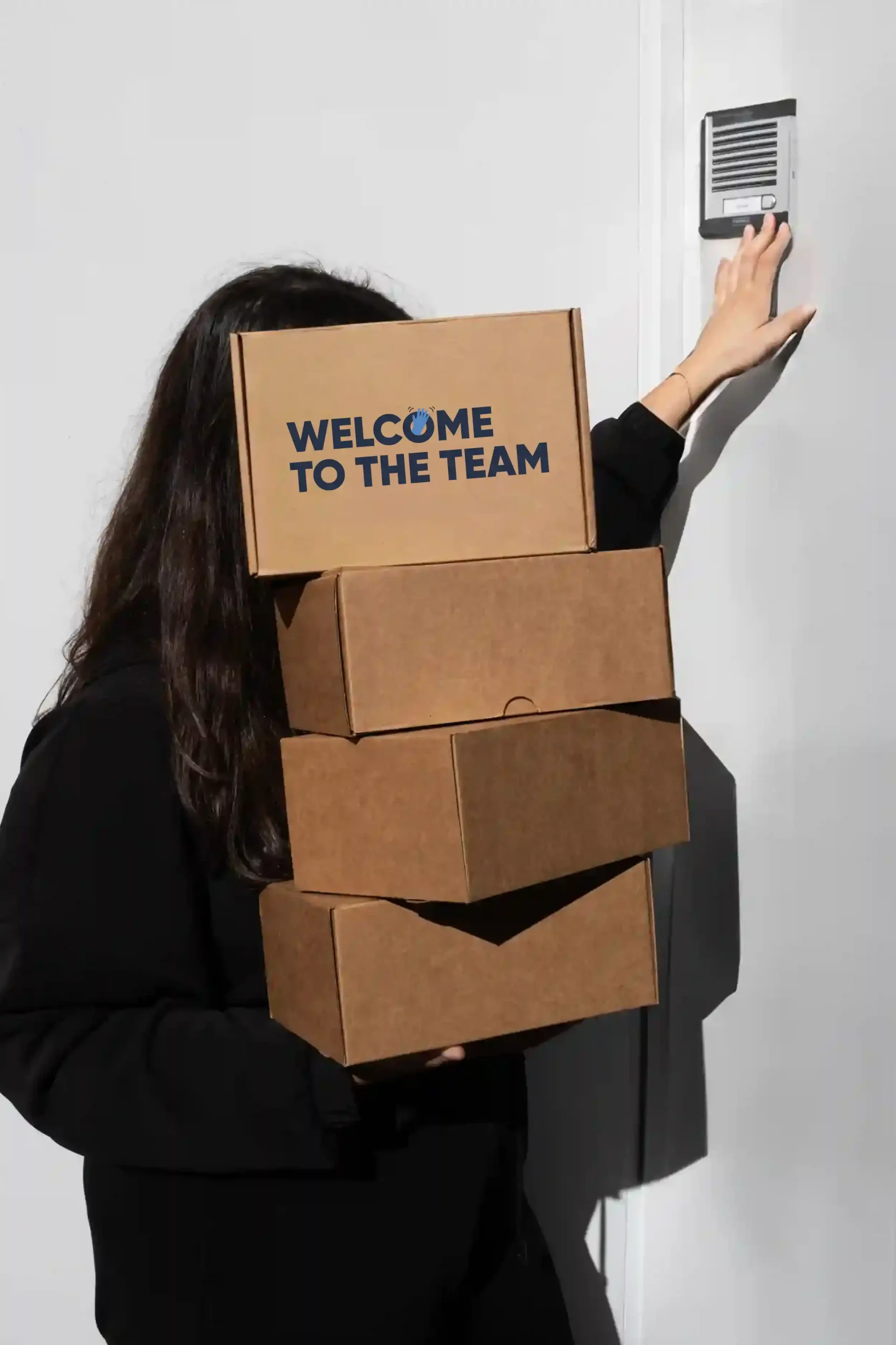 Pack 'Welcome to the team': Cajas Chica cargando cajas de cartón personalizadas con el texto 'welcome to the team'