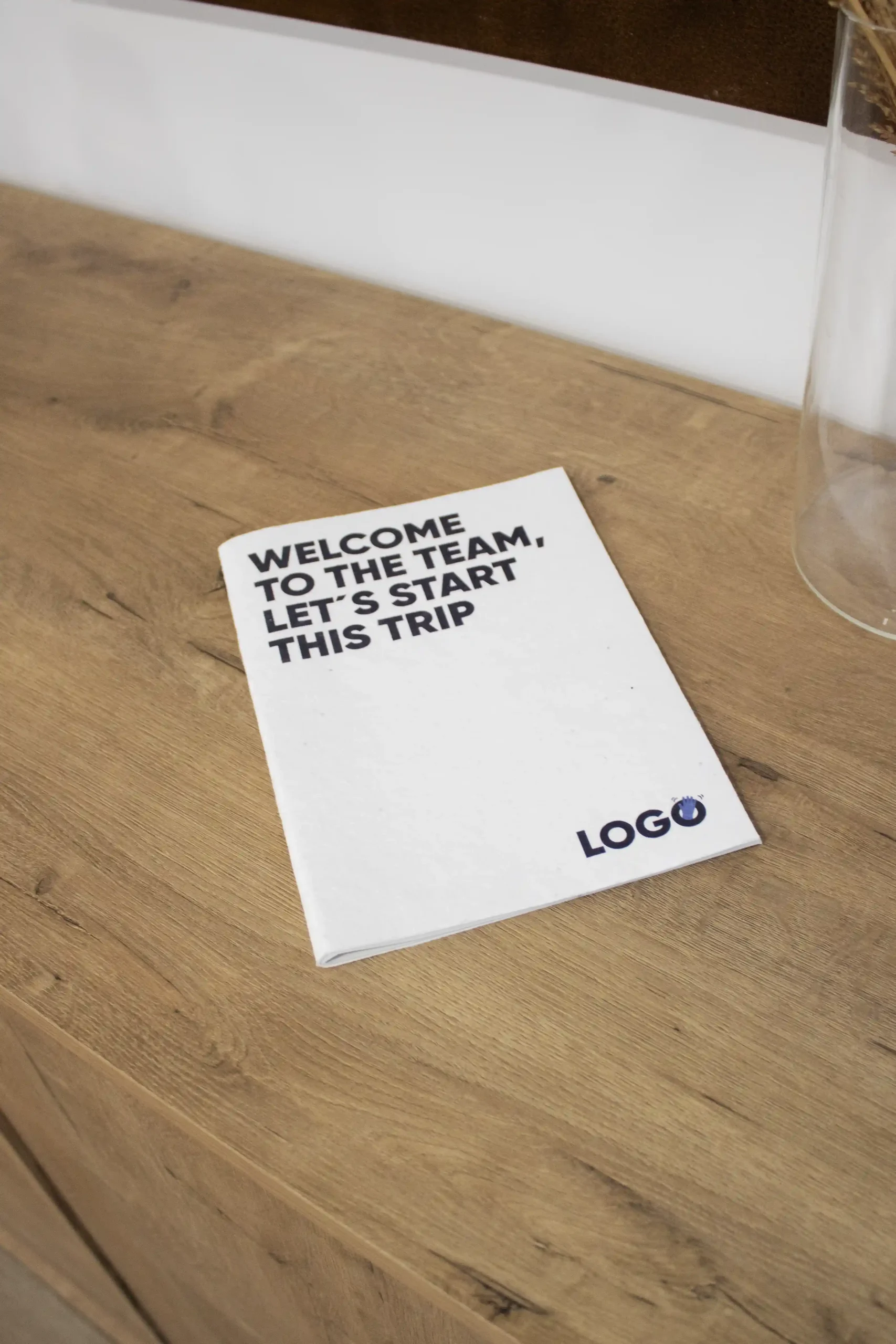 Pack 'Welcome to the team': SHON Cuaderno plantable blanco personalizado sobre una superficie de madera