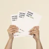 Dos manos sujetando 3 cuadernos plantables blancos personalizados con el texto 'Nature guides our steps'
