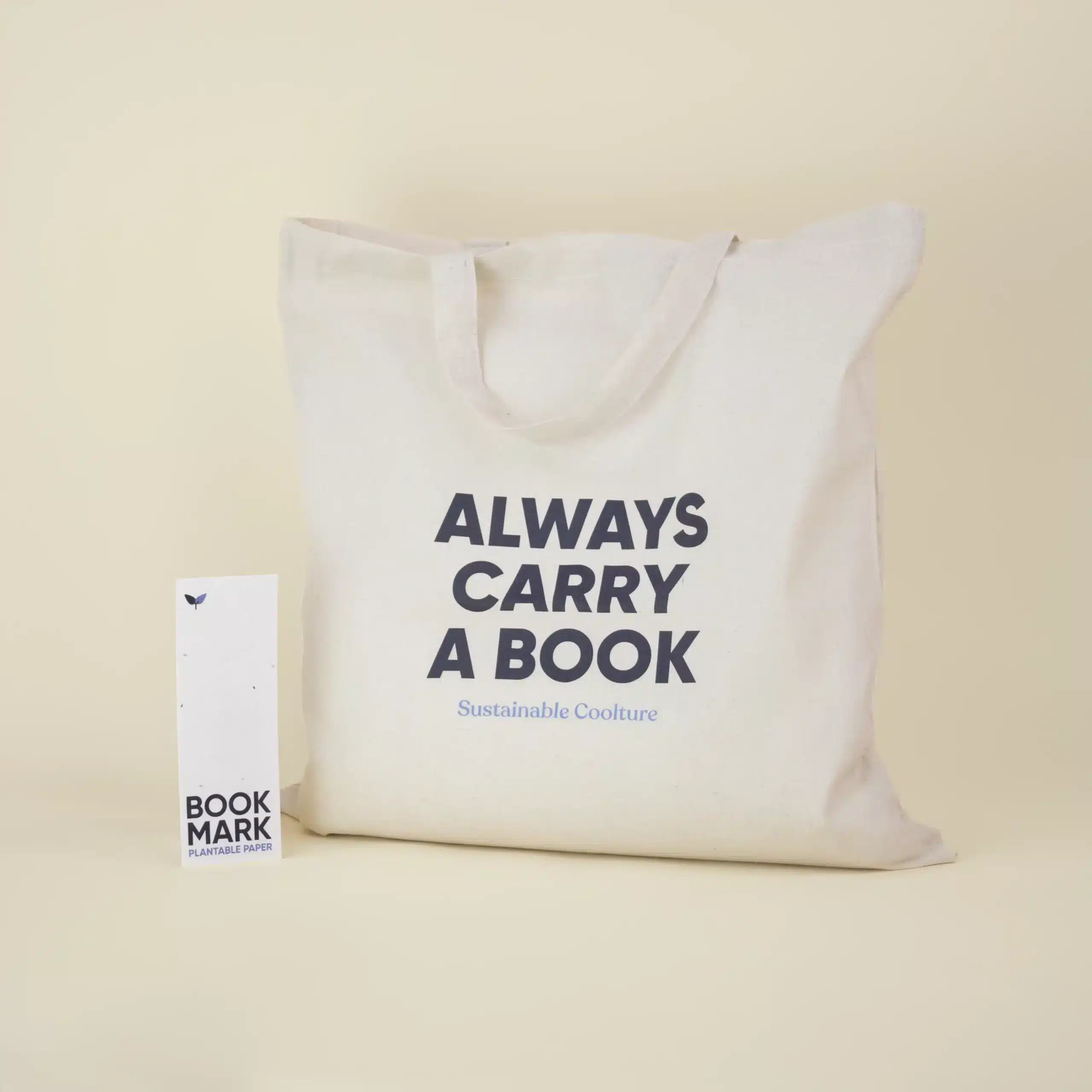 KIT CARRY A BOOK: Tote bag + Marcapáginas Bolsa de algodón beige personalizada con el texto 'Always carry a book' junto a un marcapáginas de papel plantable personalizado