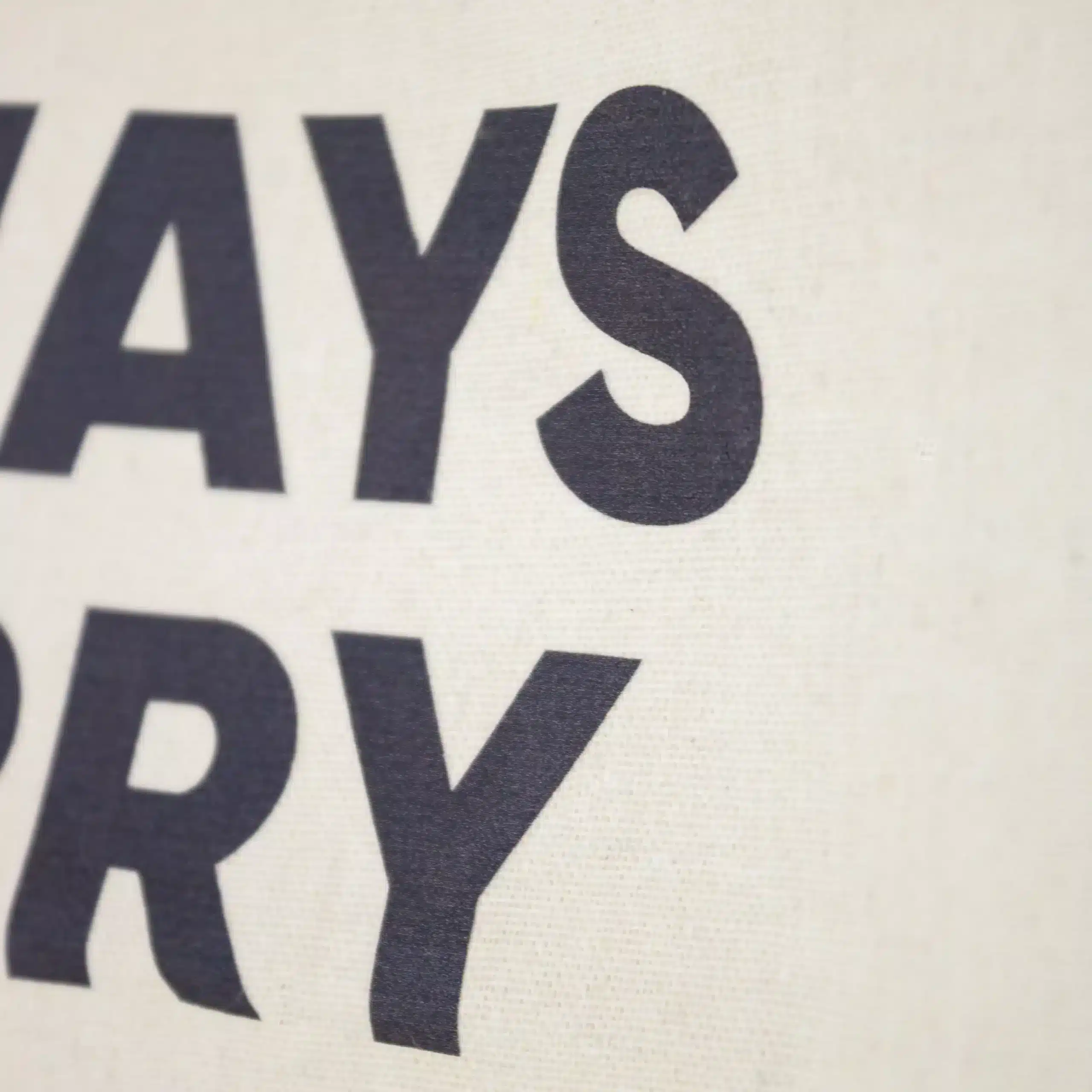 KIT CARRY A BOOK: Tote bag + Marcapáginas Detalle de impresión de una bolsa de algodón beige personalizada con textos en azul