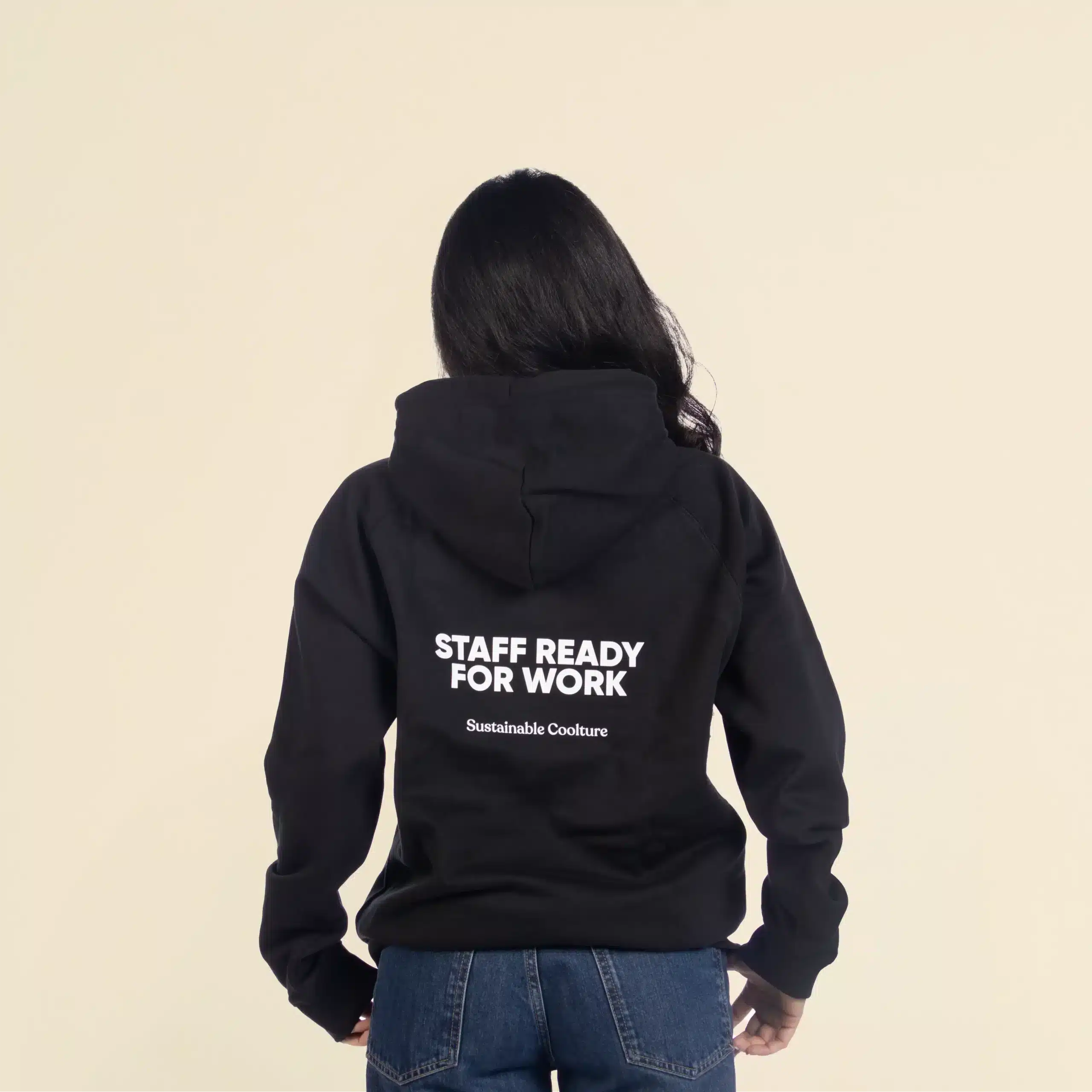 Sudadera con capucha HUVA Negro Chica morena de espaldas llevando jeans y una sudadera con capucha negra personalizada