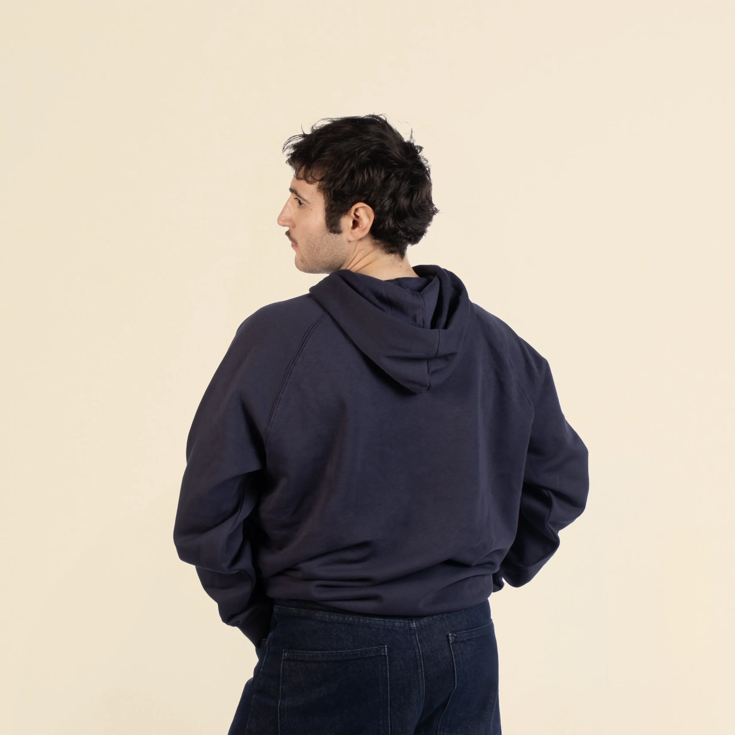 Sudadera con capucha HUVA Azul Chico moreno de espaldas llevando jeans y una sudadera con capucha azul personalizada