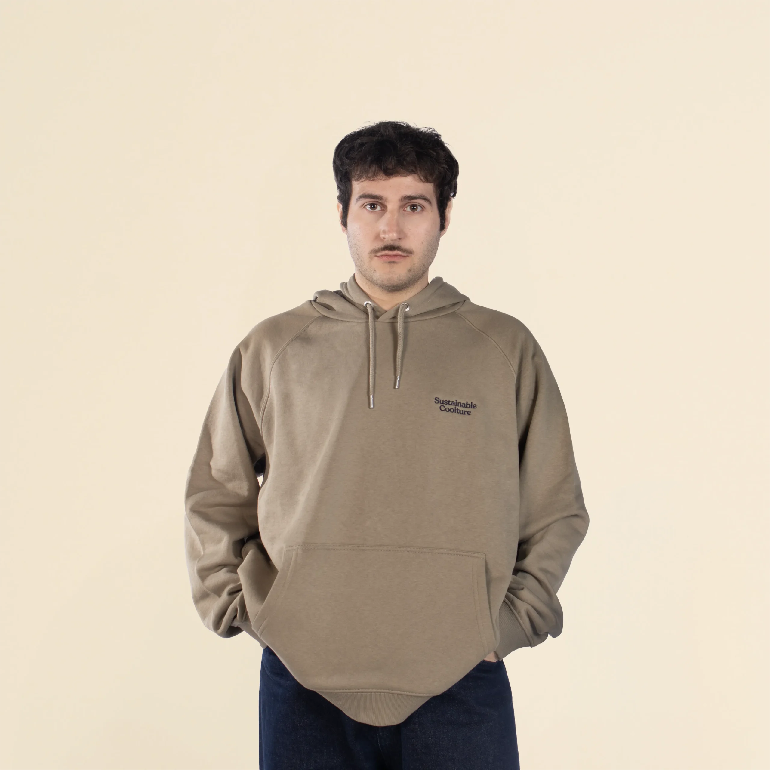 Sudadera con capucha HUVA Verde Chico moreno de frente llevando jeans y una sudadera verde con capucha personalizada