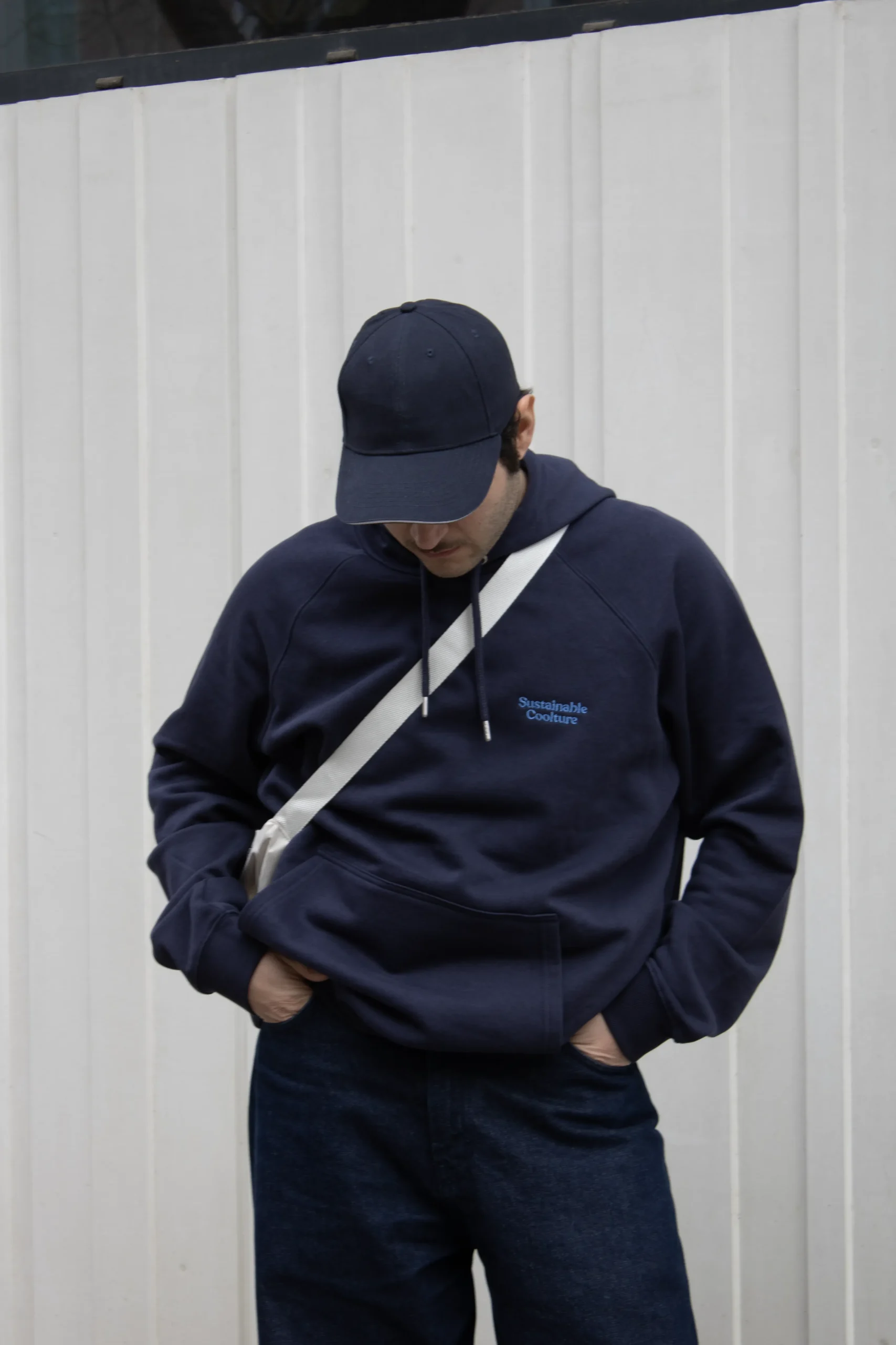 Sweat a capuche personnalisé HUVA Bleu Chico moreno con una gorra azul llevando jeans y una sudadera con capucha azul personalizada