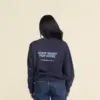 Chica morena de espaldas llevando jeans y una sudadera azul personalizada