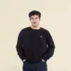 Chico moreno de frente llevando jeans y una sudadera negra personalizada