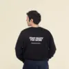 Chico moreno de espaldas llevando jeans y una sudadera negra personalizada