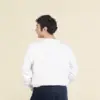 Chico moreno de espaldas llevando jeans y una sudadera blanca personalizada