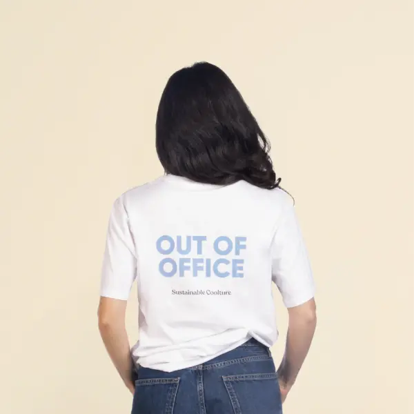 Chica morena de espaldas llevando jeans y una camiseta blanca personalizada con el texto 'out of office'