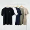 Cinco camisetas personalizadas de diferentes colores colgadas en perchas en un burro de ropa blanco