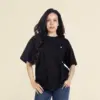 Chica morena de frente llevando jeans y una camiseta oversize negra personalizada