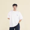 Chico moreno de frente llevando jeans y una camiseta oversize blanca personalizada