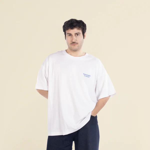 Chico moreno de frente llevando jeans y una camiseta oversize blanca personalizada