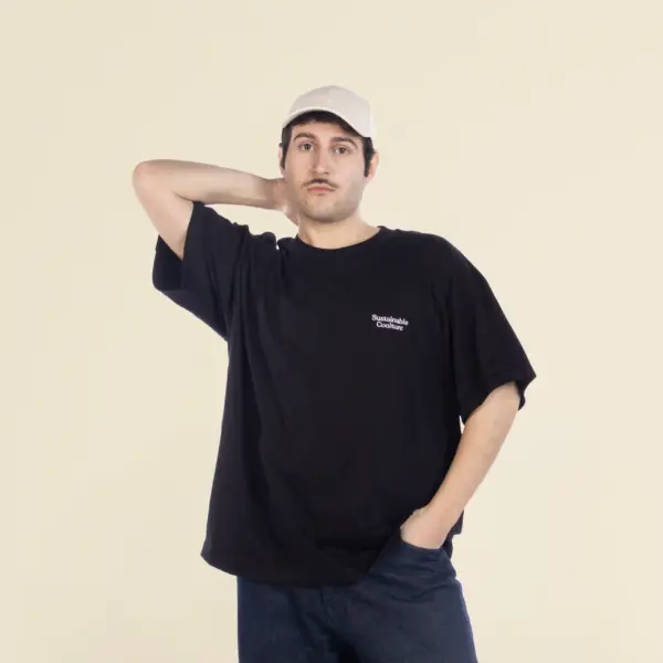 Chico moreno de frente llevando jeans y una camiseta oversize negra personalizada