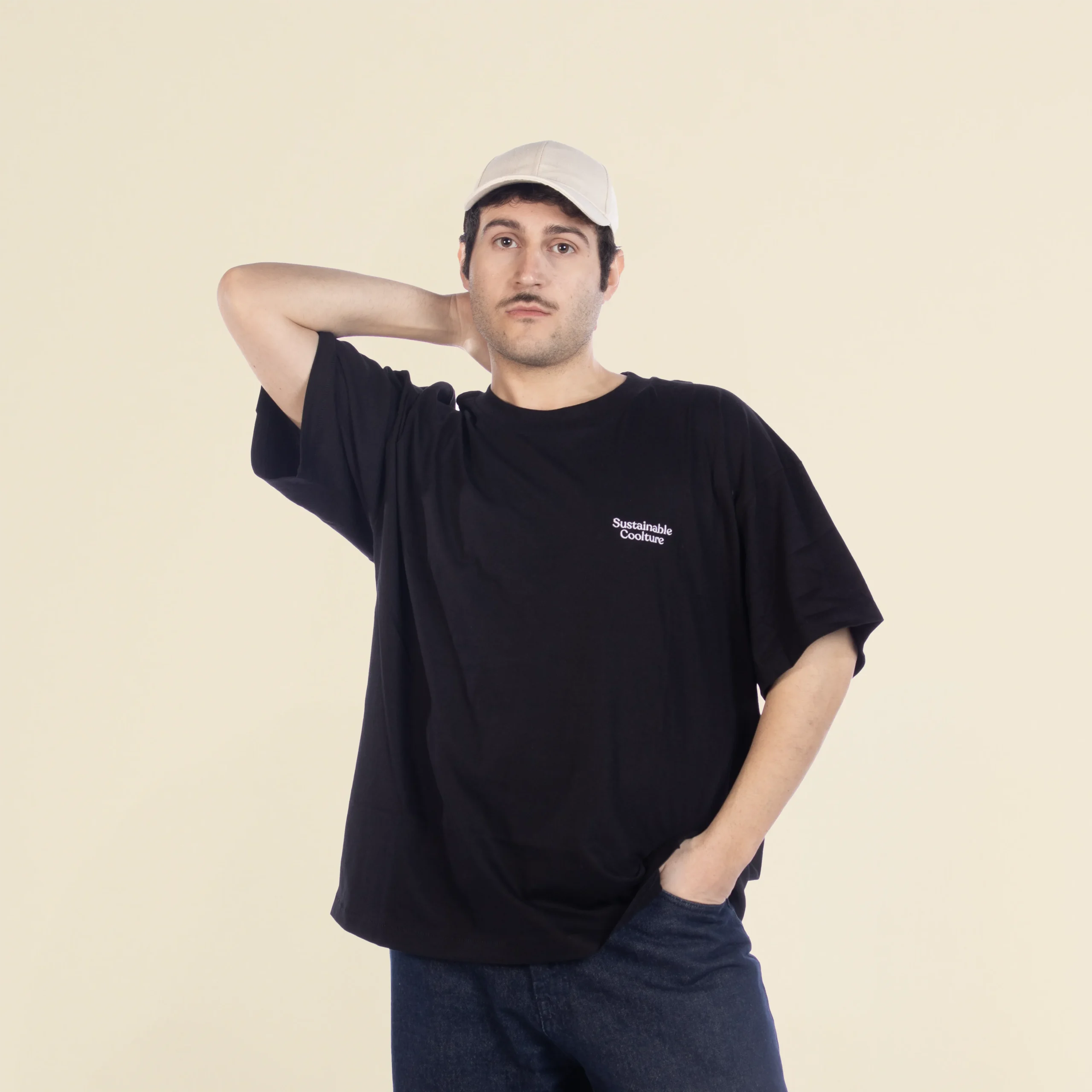 Chico moreno de frente llevando jeans y una camiseta oversize negra personalizada