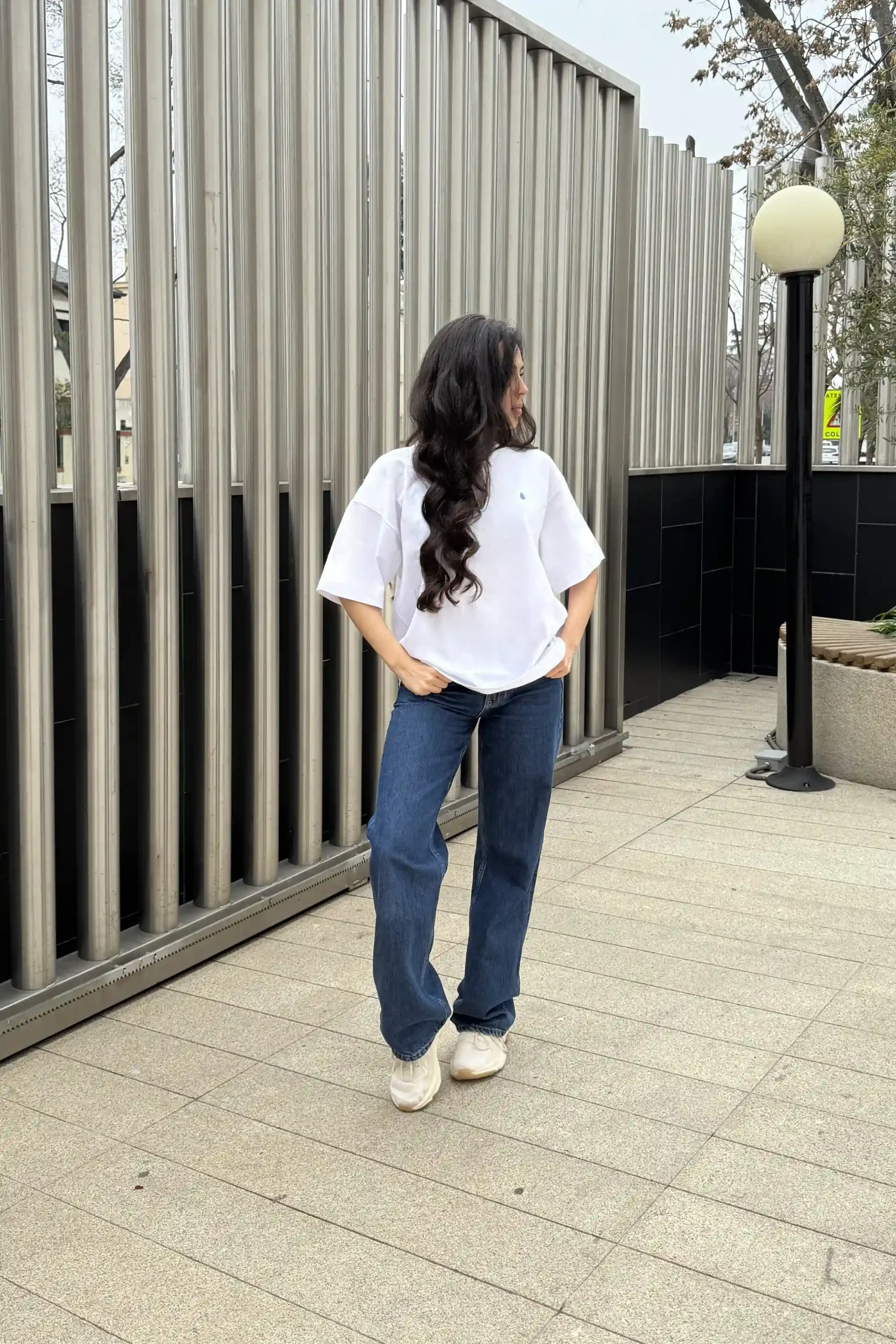 Camiseta oversize VEGA Blanca Chica morena de frente llevando jeans y una camiseta oversize blanca personalizada