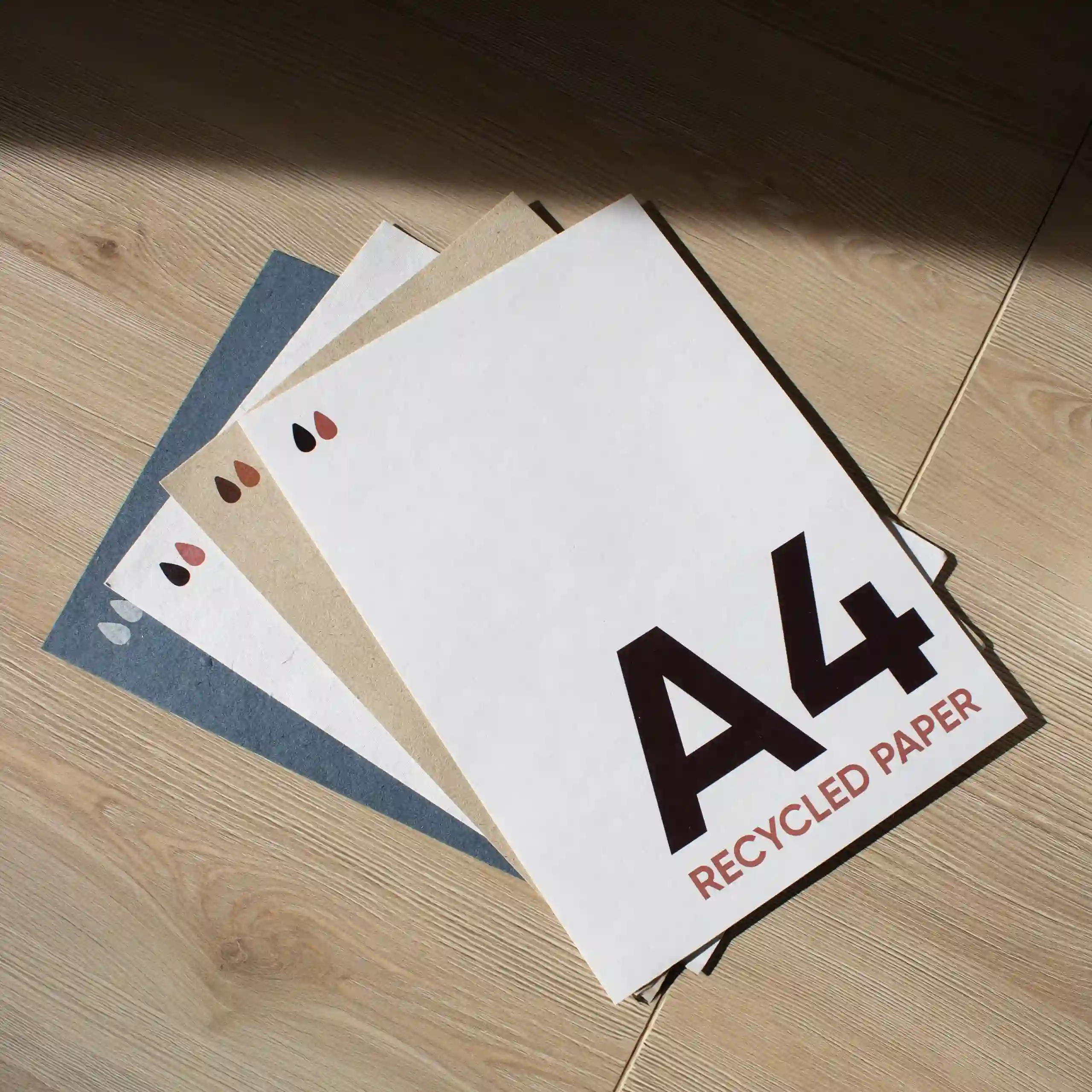Feuille A4 en papier écologique Cuatro tarjetas A4 impresas en papel ecológico sobre una superficie de madera