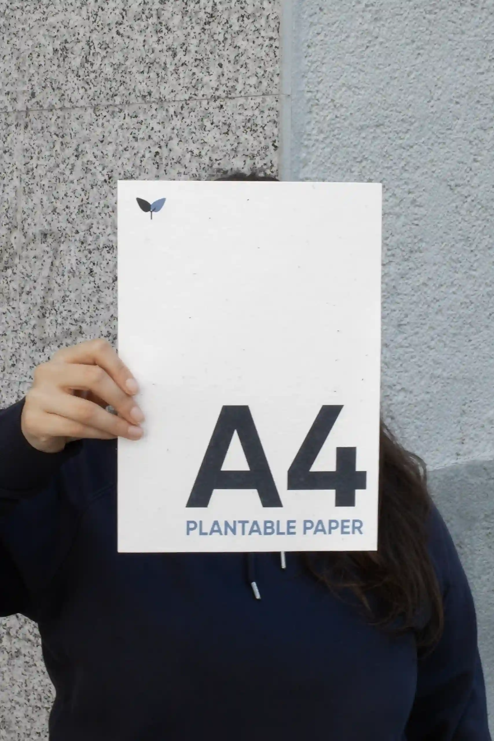 A4 plantable sheet Chica mostrando a cámara una hoja A4 impresa en papel plantable
