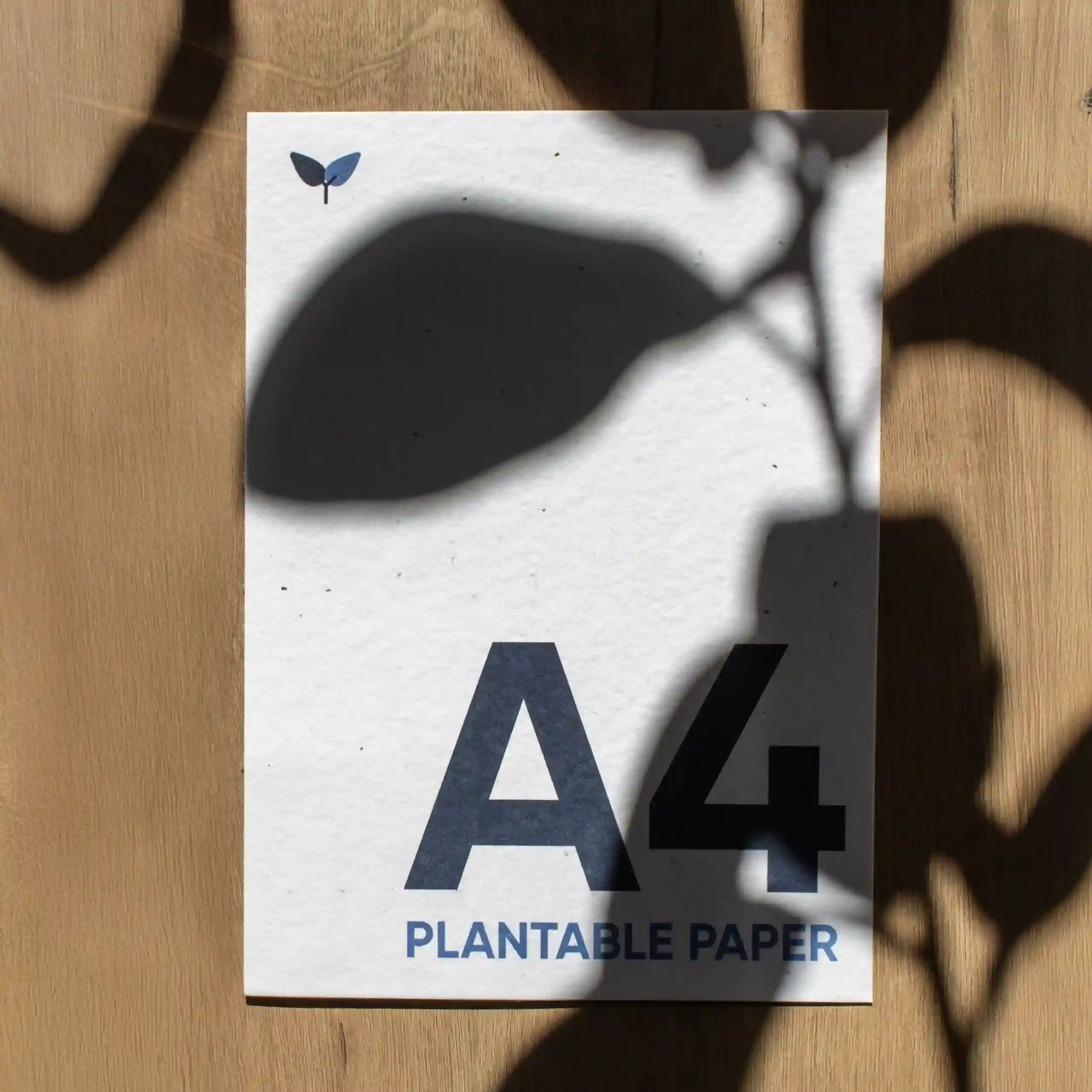 A4 plantable sheet Hoja A5 impresa en papel plantable sobre una superficie de madera con sombras