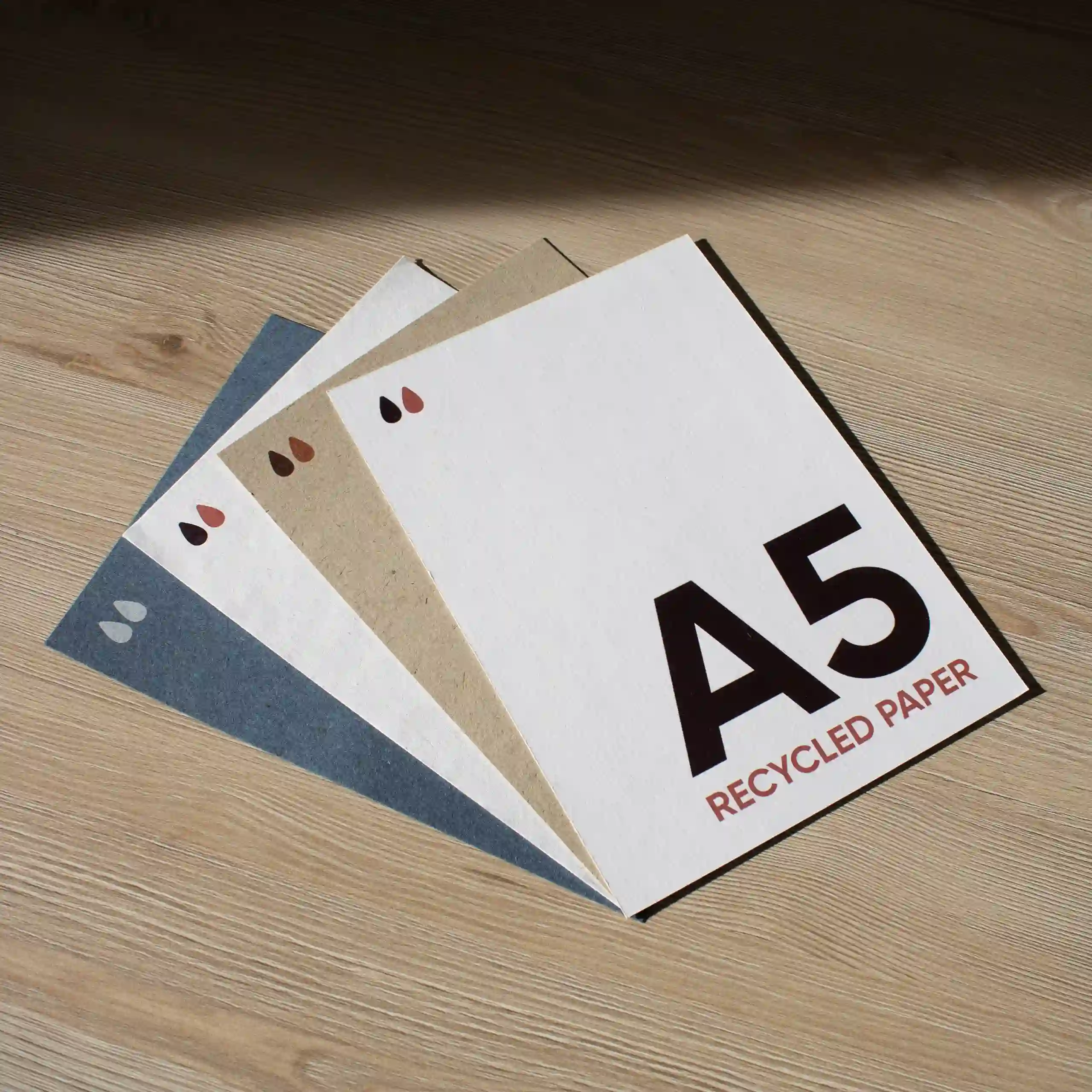 Carte A5 en papier écologique cuatro tarjetas A5 impresas en papeles ecológicos sobre una superficie de madera