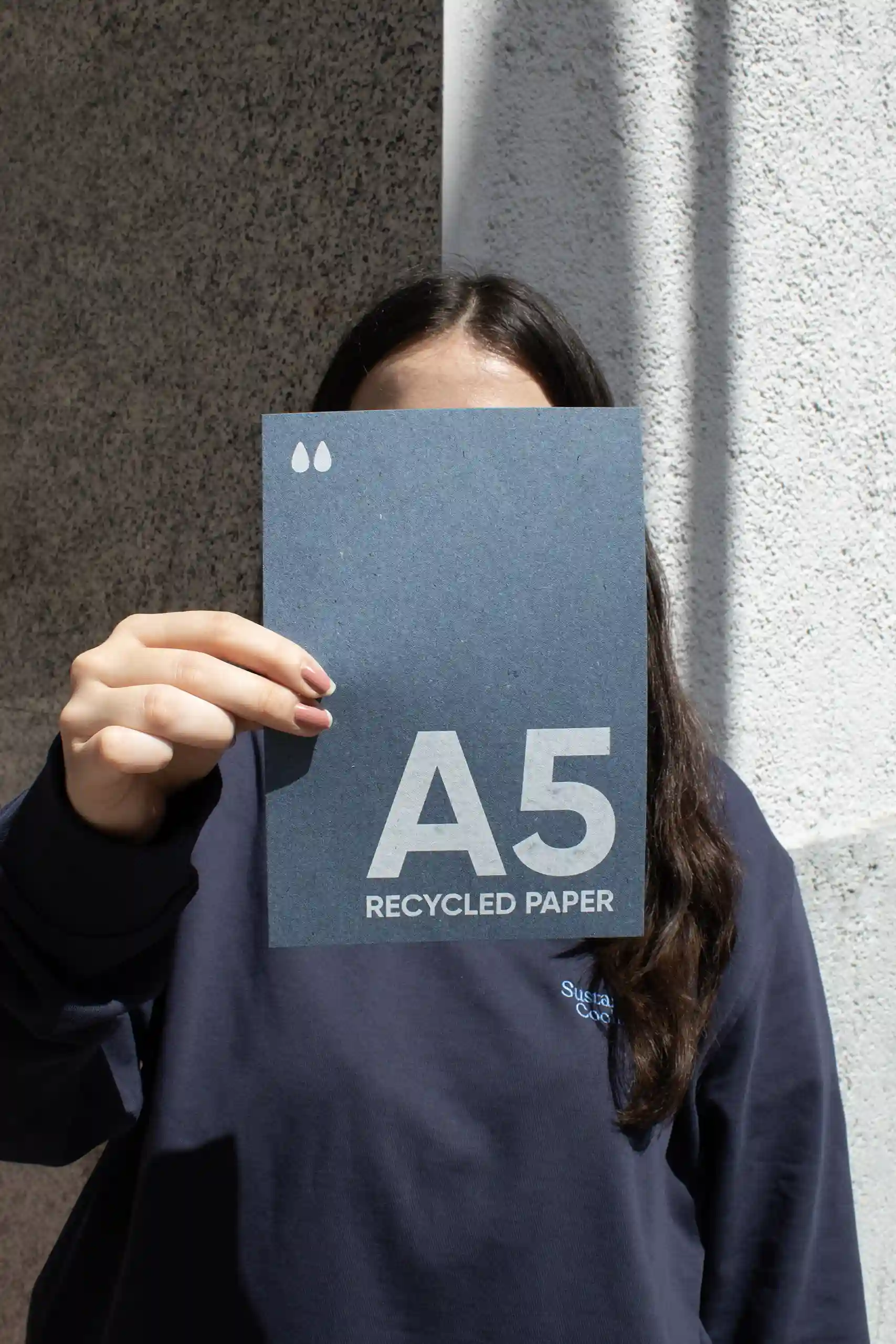 Carte A5 en papier écologique Chica mostrando a cámara una tarjeta A5 impresa en papel ecológico