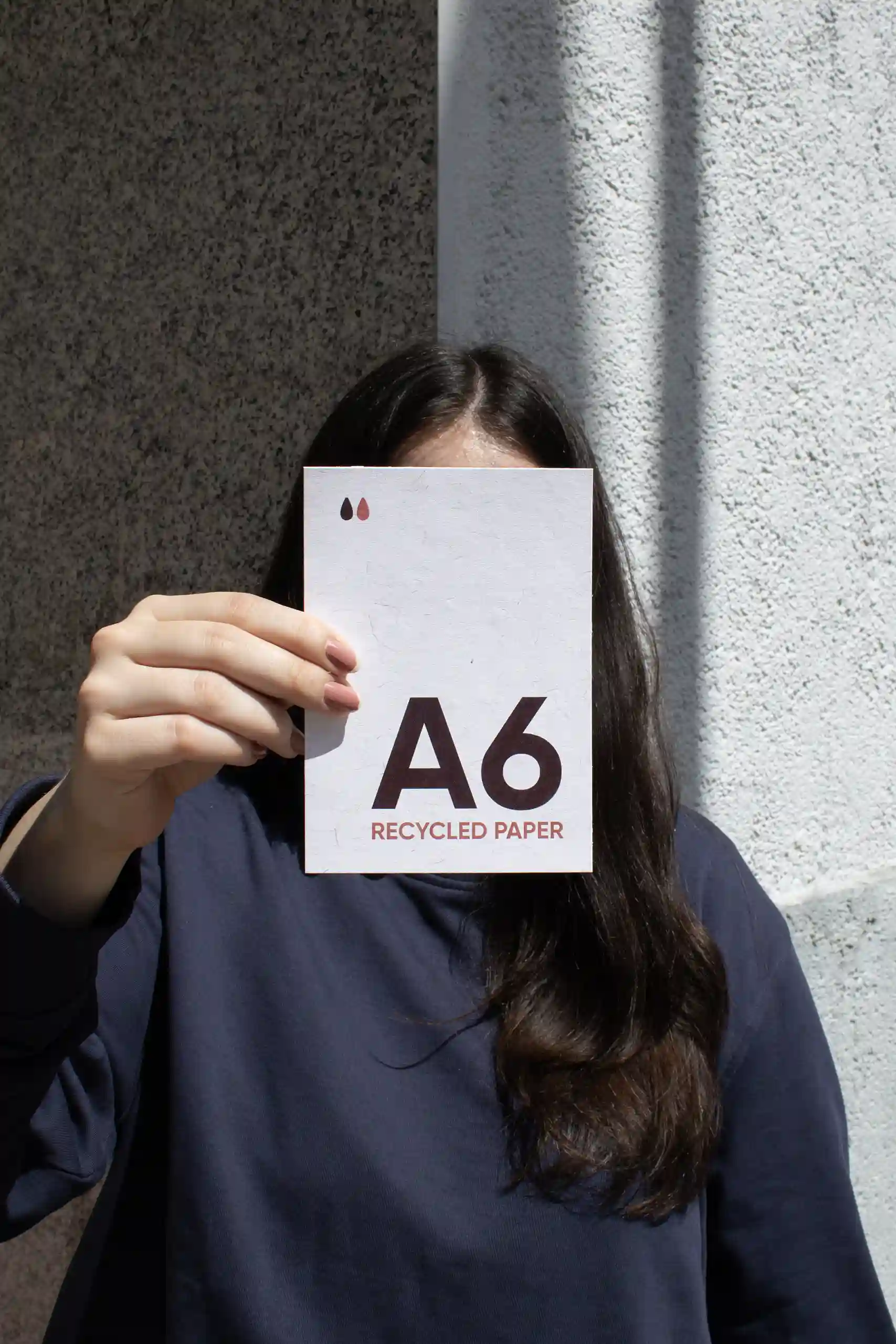 A6 eco-friendly flyer Chica mostrando a cámara una tarjeta A6 impresa en papel ecológico