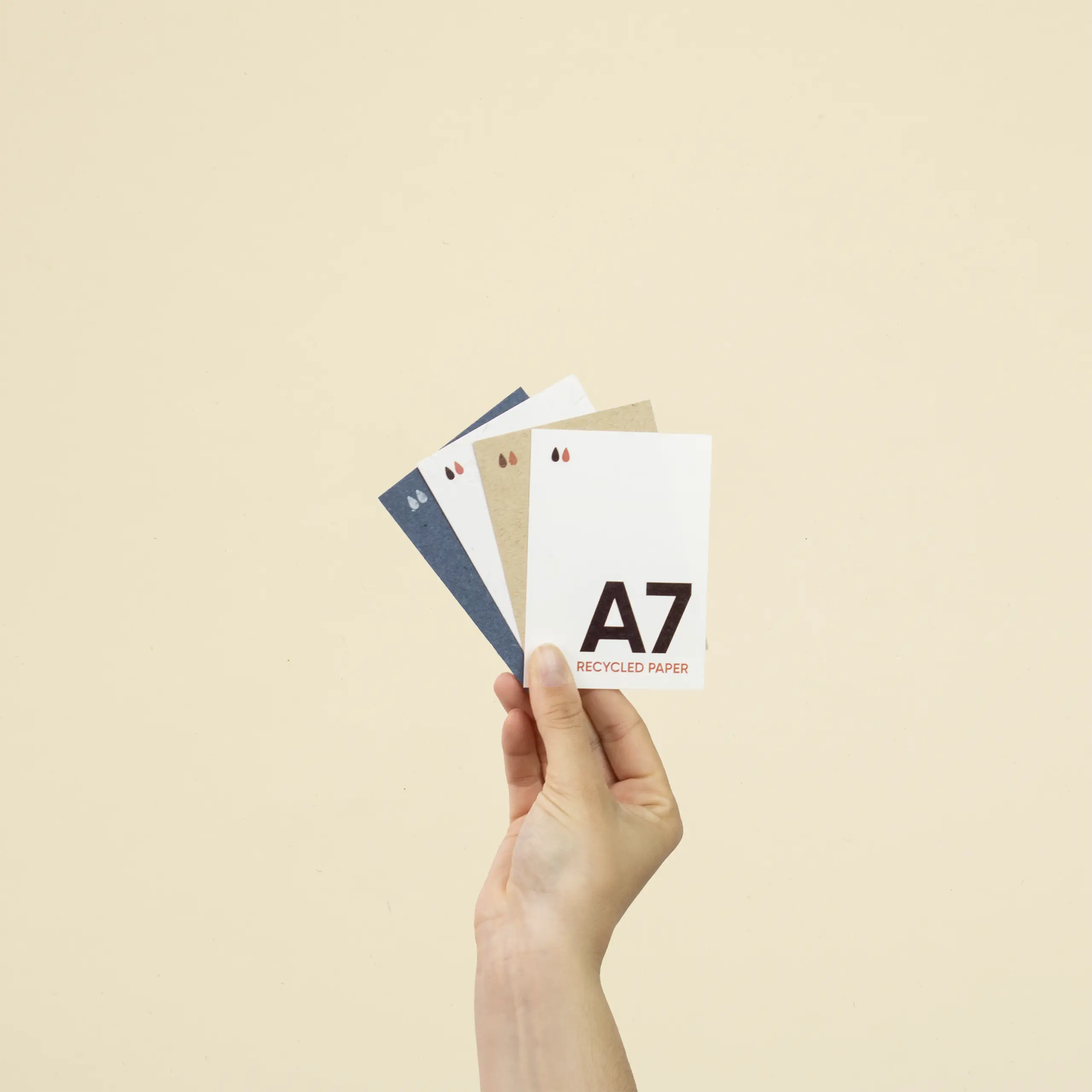 Tarjeta papel ecológico A7 Mano sujetando cuatro tarjetas A7 impresas en papeles ecológicos