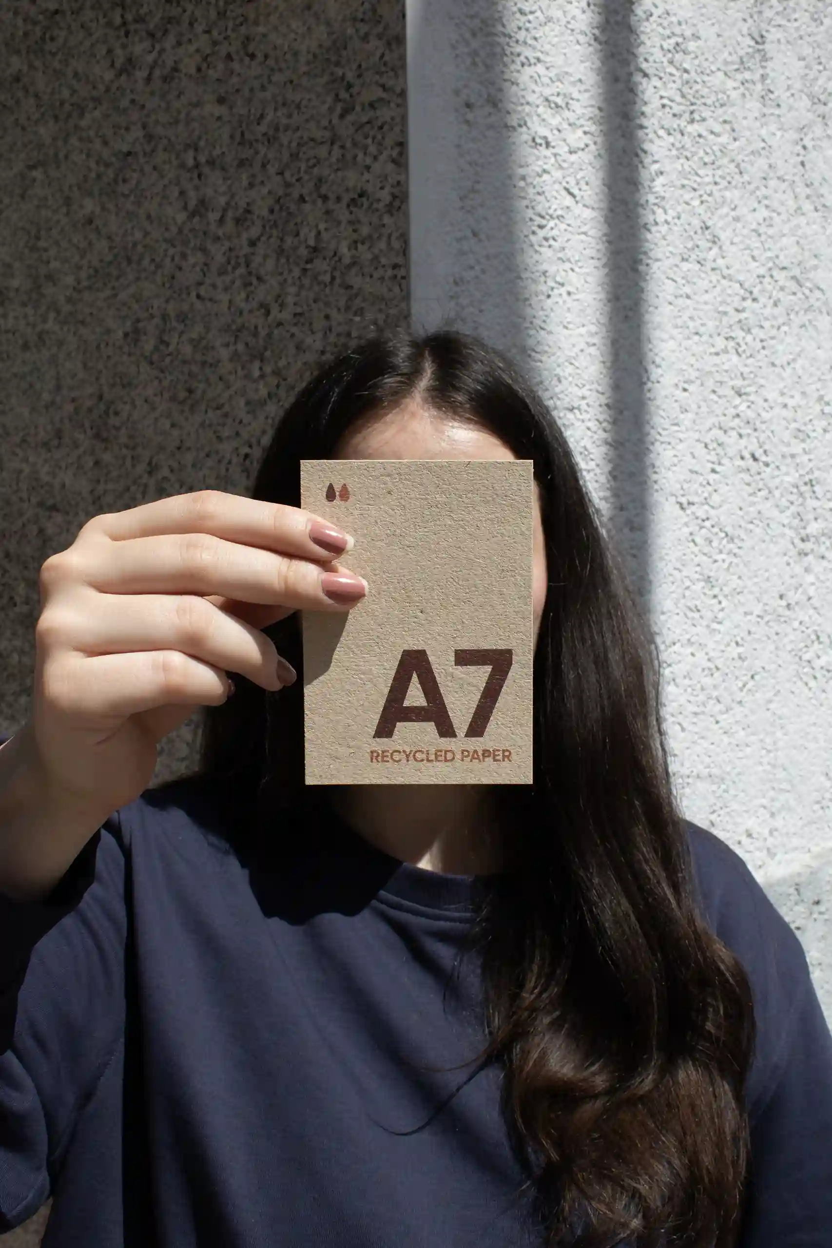 Carte A7 en papier écologique Chica mostrando a cámara una tarjeta A7 impresa en papel ecológico