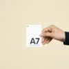 Mano mostrando una tarjeta A7 impresa en papel plantable