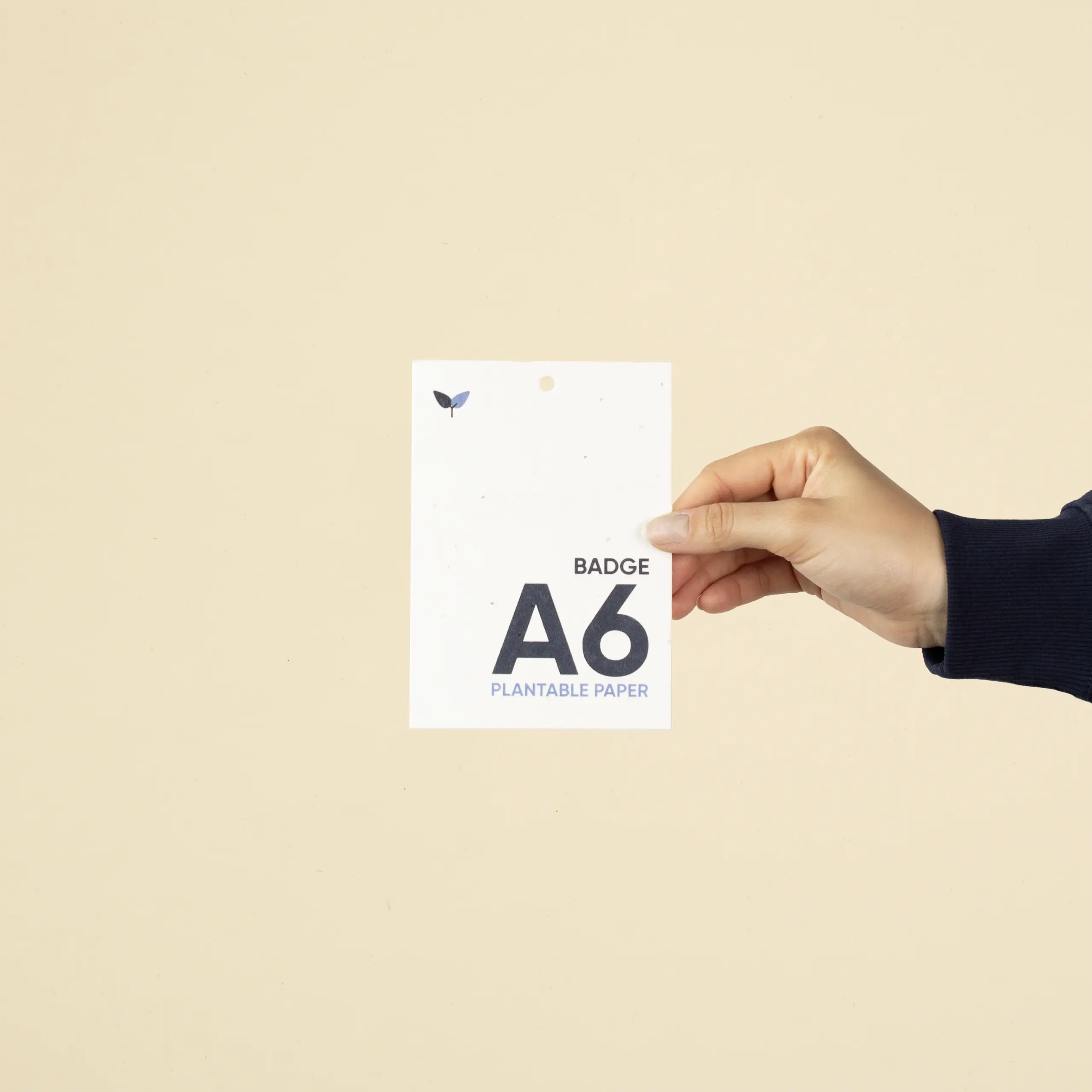 Mano mostrando una acreditación A6 impresa en papel plantable