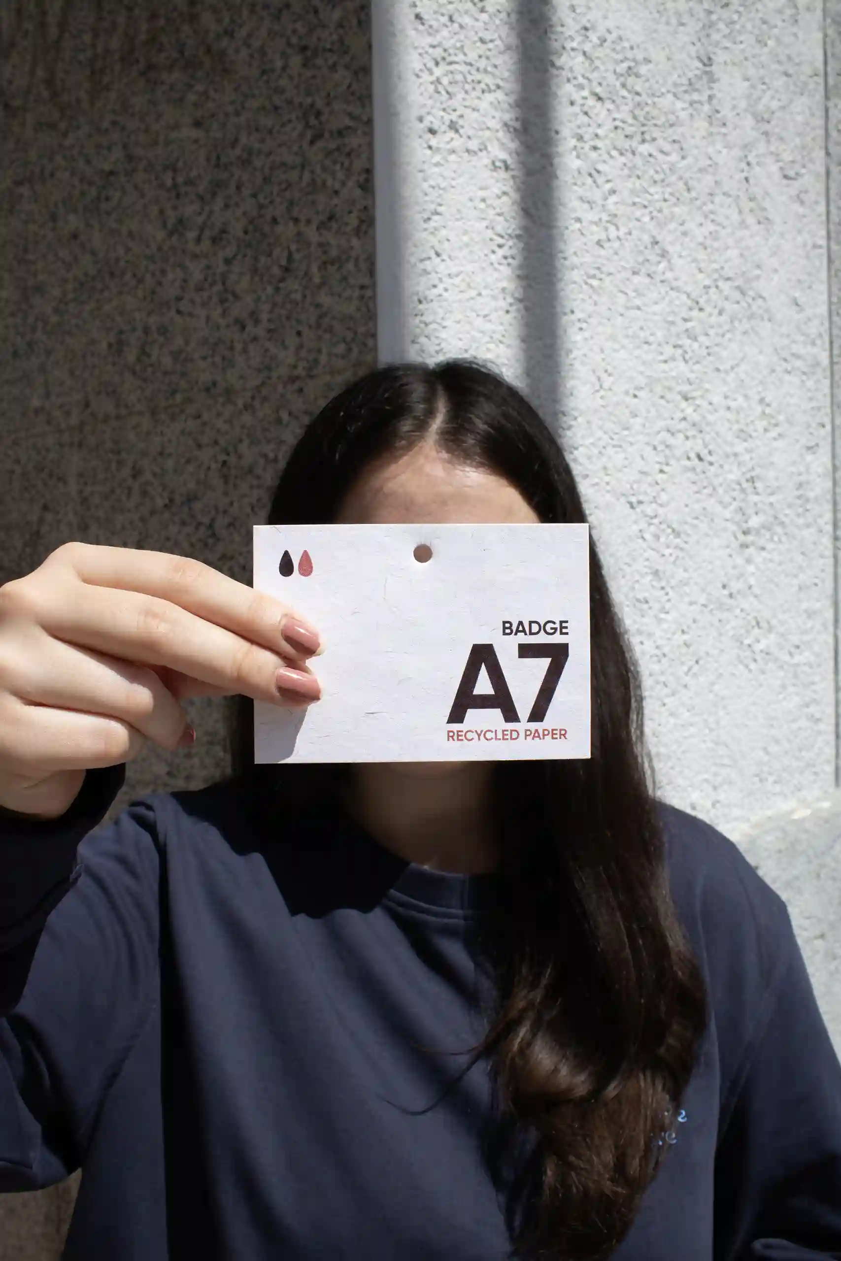Badge A7 en papier écologique Chica mostrando a cámara una acreditación A7 impresa en papel ecológico