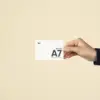 Mano mostrando una acreditación A7 impresa en papel plantable