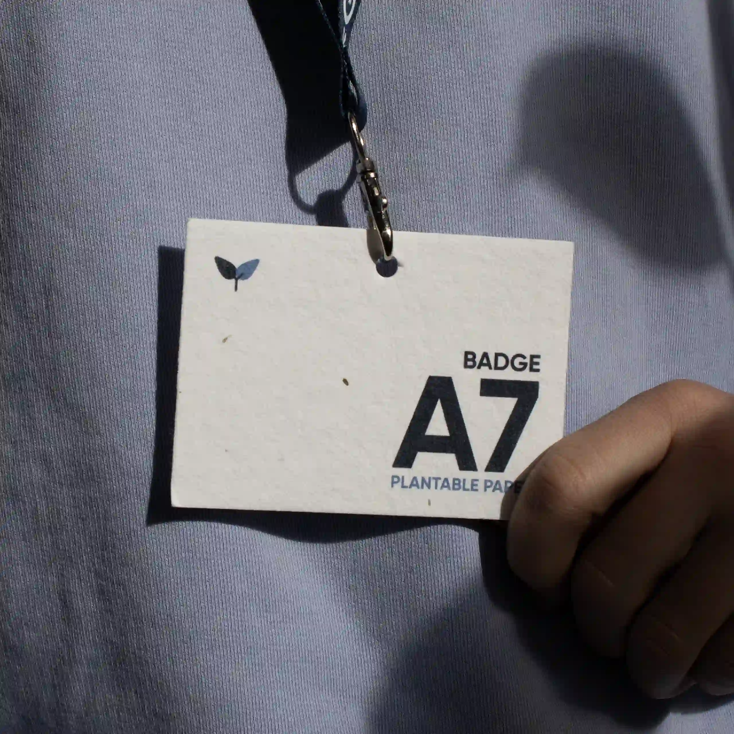 Badge plantable A7 Acreditación A7 impresa en papel plantable con lanyard colgada del cuello de una persona