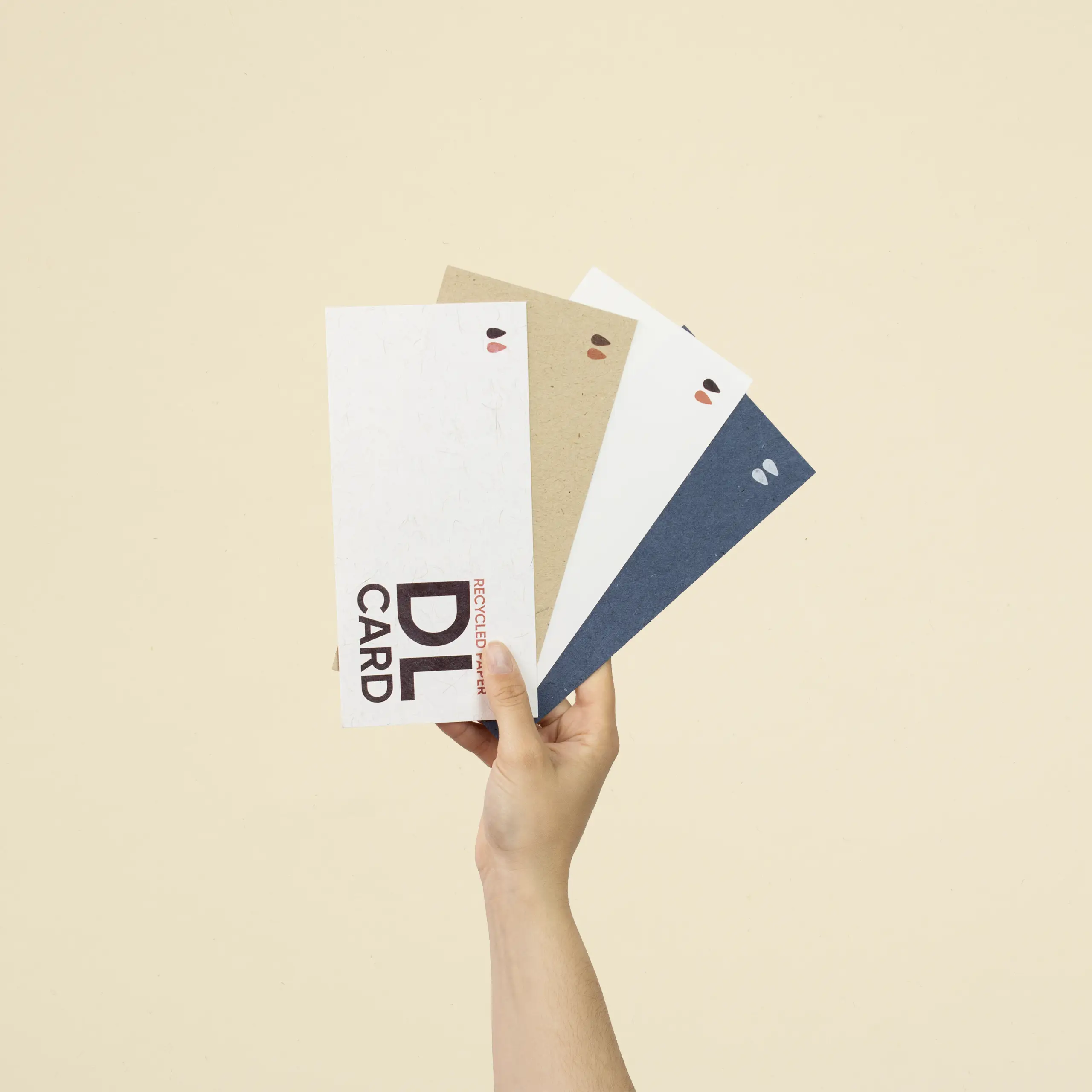Tarjeta papel ecológico DL Mano sujetando cuatro tarjetas DL impresas en papel ecológico