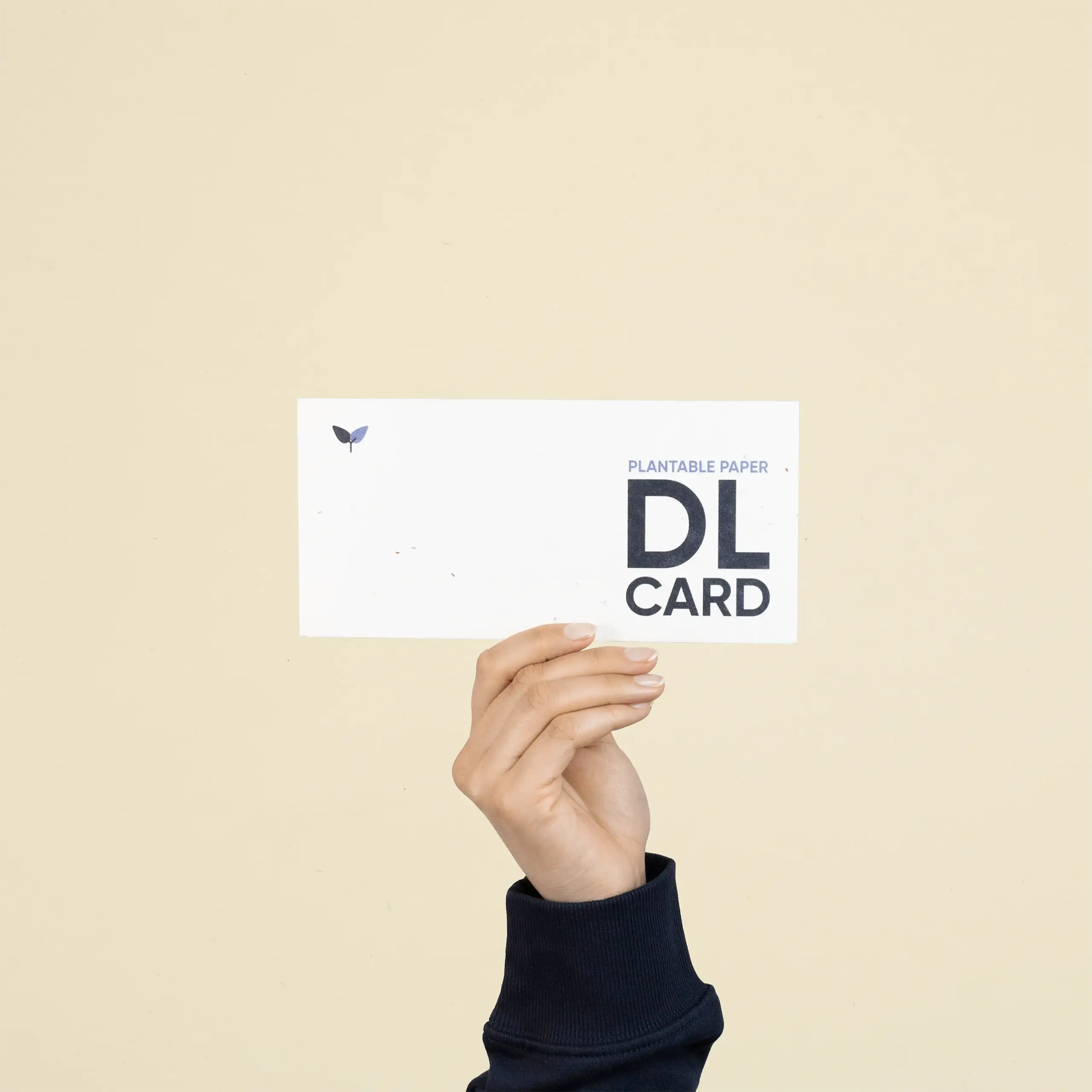 Mano mostrando una tarjeta DL impresa en papel plantable