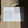 Díptico A5 abierto impreso en papel plantable sobre una superficie con sombras